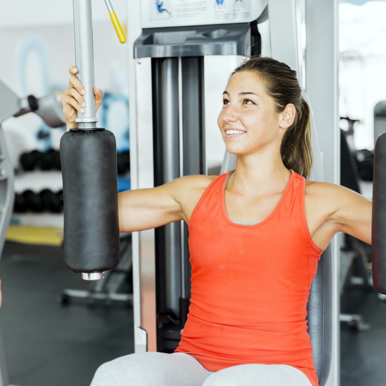 Young male trainer giving instructions to a woman in a gym