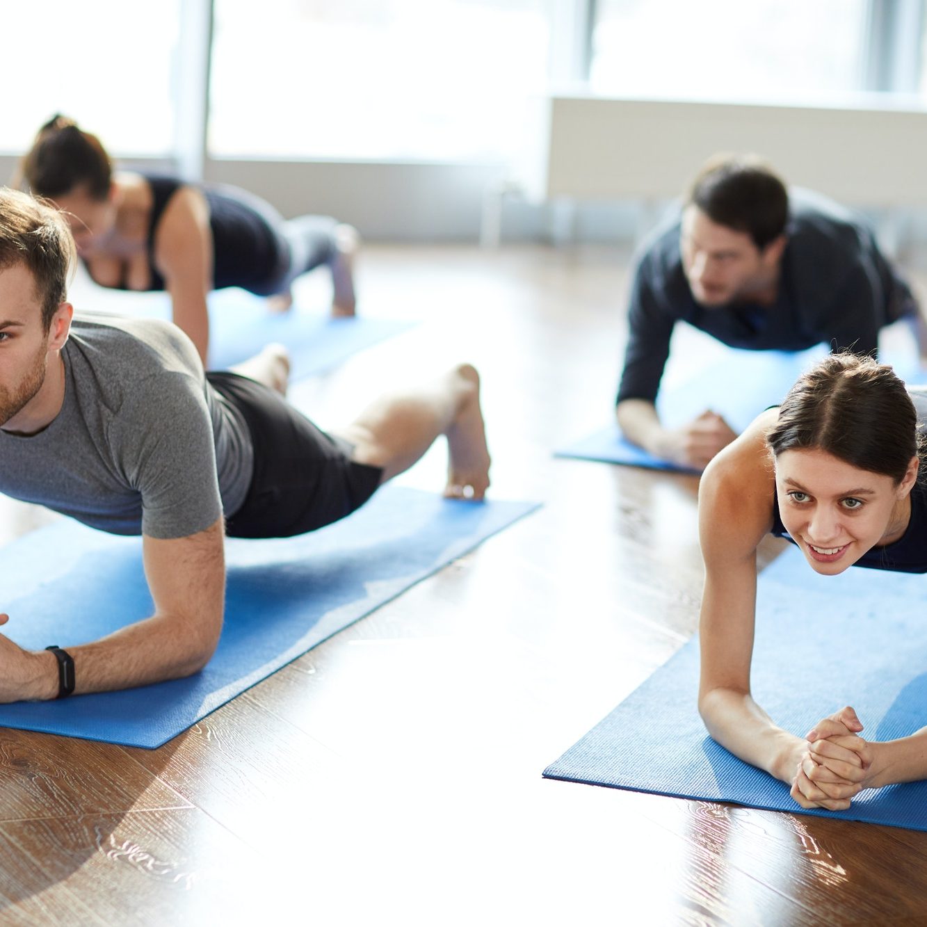 Motivated young people doing elbow plank