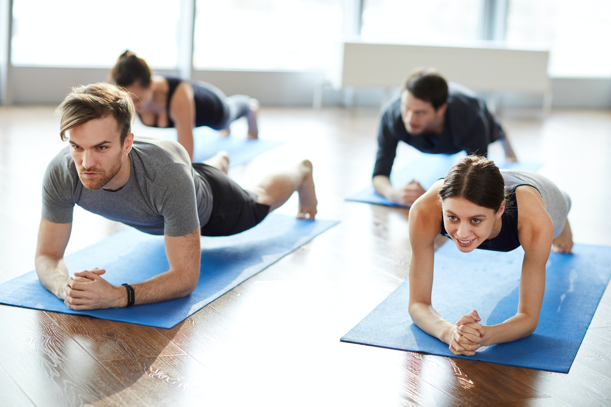 Motivated young people doing elbow plank