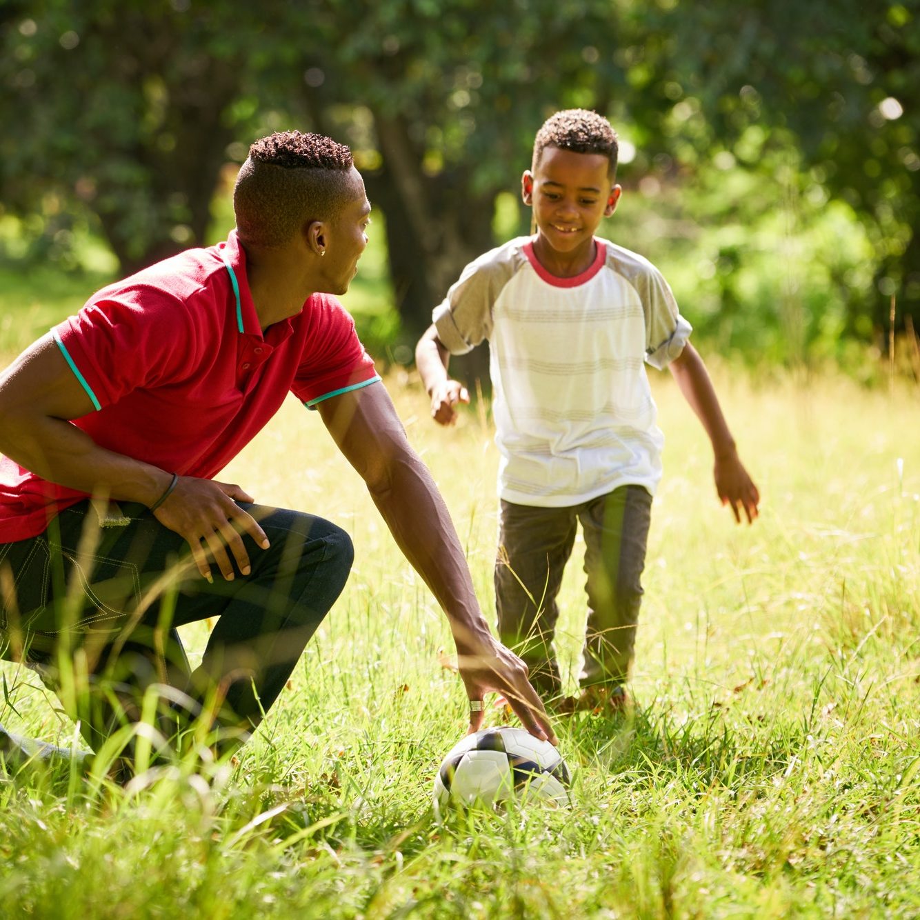 Sport Practice With Father Teaching Son How To Play Soccer